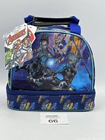 Front view of the lunch bag showing Black Panther, Shuri, and Nakia with blue and purple graphic design and bottom zippered compartment with claw prints.