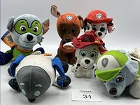 Photo of six Paw Patrol plush toys arranged in a group showing their faces and hats.