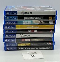 Stack of 9 PS4 game cases showing spines: NHL 18, Grand Theft Auto V, Saints Row, Mortal Kombat 11, WWE 2K18, NHL 19, LEGO Marvel Collection, Borderlands, Fast & Furious Crossroads.