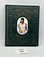 Front cover of 'From Crook to Cook' cookbook by Snoop Dogg, showing dark green cover with gold text and photo of Snoop Dogg.