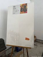 Photo showing front view of the canvas mounted on the easel with printed label indicating brand and size.