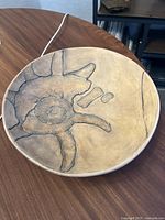 Top view of the bowl showing the hand-painted abstract design on beige pottery.