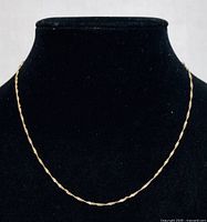 Front view of the yellow gold twisted rope chain necklace displayed on a black jewelry bust showing full length and delicate design.