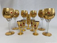 Full set of 11 Italian Venetian liqueur glasses showing gold gilding and red jeweled embellishments
