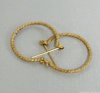 Two yellow gold rope-textured hoop earrings overlapping