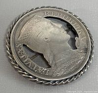 Front view of the brooch showing the Latvian Republic profile on the 5 Laati coin mounted with a twisted silver frame.
