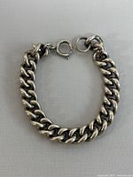 Full view of silver link chain bracelet with round spring clasp.