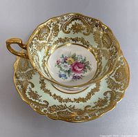 Top view of the vintage Paragon teacup on matching saucer displaying floral center and gold gilt details