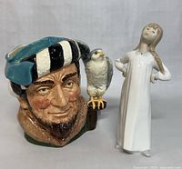 Photo showing both figurines together: Royal Doulton Toby Jug and Lladro Nao girl figurine