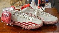 Side view of one Adidas Adizero 5 Star 3.0 Mid football cleat showing white diamond pattern upper and red gradient sole with red Adidas stripes