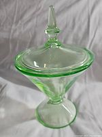 Full view of the vintage uranium glass candy jar with lid, showing the flared cone shape and pointed lid.