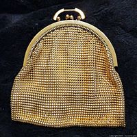 Full view of the vintage gold mesh purse showing its rounded shape and metallic finish.