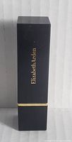 Front angle of black Elizabeth Arden lipstick case with gold branding and trim.