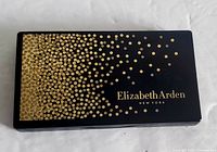 Closed Elizabeth Arden makeup palette showing black rectangular case with gold dot design and Elizabeth Arden logo on top lid.