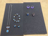 Full lot showing all jewelry items: turquoise necklace, bracelet, turquoise stud earrings, purple crescent hoop earrings, and two rings (blue stone and purple stone).