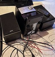 Sony two-speaker audio system with main unit and connecting wires shown from rear and sides.
