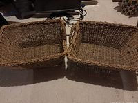 Top view of two rectangular wicker baskets placed side by side on a carpeted floor
