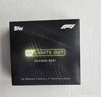 Front view of the black box labeled 'F1 Lights Out Season 2021' with Topps and F1 logos and text '25 premium Formula 1 trading cards'.