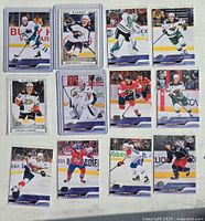 Photo of 11 Upper Deck 2023-24 NHL Young Guns and rookie glossy hockey cards showing action shots of players.