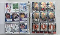 Photo showing two open binder pages with various NBA mosaic basketball cards in protective sleeves.