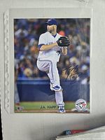 Full color 8 x 10 photo of J.A. Happ pitching in Toronto Blue Jays uniform with autograph on the front.