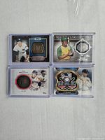 Four Topps MLB baseball cards featuring Mickey Mantle, Ted Williams, Ty Cobb, and Reggie Jackson with medallions embedded in each card.