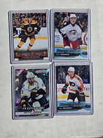 Front view of four hockey cards: Dougie Hamilton in Bruins uniform, Zach Werenski in Blue Jackets uniform, Seth Jones in Predators uniform (Prizm Cracked Ice rookie), and Ivan Provorov in Flyers uniform all in plastic sleeves.