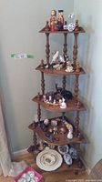 Full view of the five tier wooden corner shelf holding assorted collectible miniatures, showing overall arrangement and size.