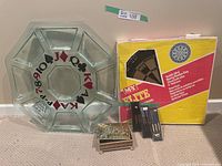 Overview of the dartboard box, large decorative glass serving tray, tins and dart sets