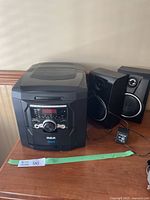 Full view of RCA 5 disc CD player unit with two speakers and power adapter on table.