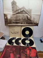 Full view of box set with four LP vinyl records, cream-colored sleeves with cut-out Chicago logo, and large poster of building.