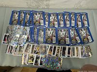 Overview of multiple opened and unopened basketball sticker and card packs spread on surface.