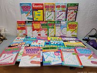 Overview of the puzzle book collection showing multiple crossword and word search books arranged on a table.