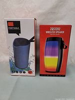 Front view of the two speaker boxes displaying product images and main features