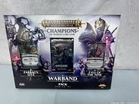 Front view of the sealed Warhammer Age of Sigmar Champions Warband Pack Series 02 box showcasing the three included decks: Zarbags Gift, Savagery, and Eyes of the Nine.