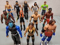 Full view of all 12 WWE wrestling figures arranged in three rows showing variety in costumes and colors.