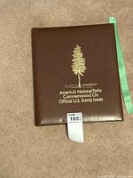 Brown binder with gold embossed tree and text reading 'America's National Parks Commemorated on Official U.S. Stamp Issues'