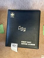 Closed black WRP Uni-Safe First Day Cover Album binder with gold lettering.
