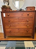 Front view of entire dresser showing two small top drawers, four larger drawers, spool-turned front supports