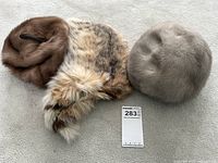 Three fur hats shown side by side for inventory, various colors and styles.