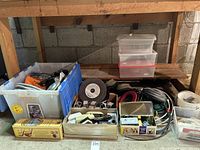Wide view of multiple storage bins and containers filled with various electrical wires, cables, electrical tape rolls, and small electrical components.