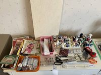 Full overview of the sewing lot showing threads, pattern books, scissors, bobbins, pin cushions, and other notions