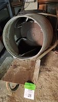 View inside the drum of the cement mixer revealing the internal mixing paddles and signs of use.