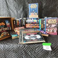 Overview of hardcover sci-fi books showing Star Trek, Star Wars titles, and other fantasy works including Star Trek technical manuals lying flat.