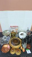Overview of lot on black surface with multiple serving dishes, decor figurines and glass cups