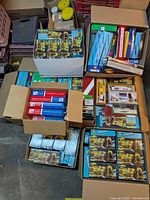 Eight top-down view of multiple boxes filled with model train kits and packaged cars