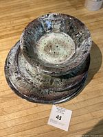 Top view of the stacked dinnerware pieces showing speckled metallic effect on the bowls and plates.