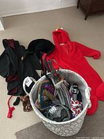 Full lot overview showing multiple costumes and items in a laundry basket plus some laid beside it