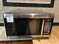 Front view of microwave showing closed door with control panel and digital display at 0:00.
