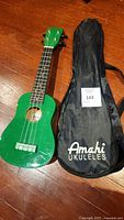 Full view of the green Denver ukulele and the black Amahí Ukuleles soft case